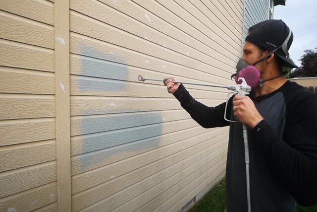 Contractor painting exterior of a home