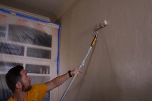 Worker painting the wall with a roller